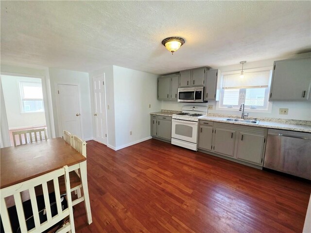 5 Rosemont Ter, North Providence, RI 02911 - kitchen with stainless steel appliances, a sink, gray cabinetry, dark wood-style floors, and light countertops