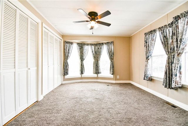 40 Lowell Ave, Pawtucket, RI 02861 - unfurnished bedroom with multiple windows, carpet flooring, two closets, crown molding, and ceiling fan