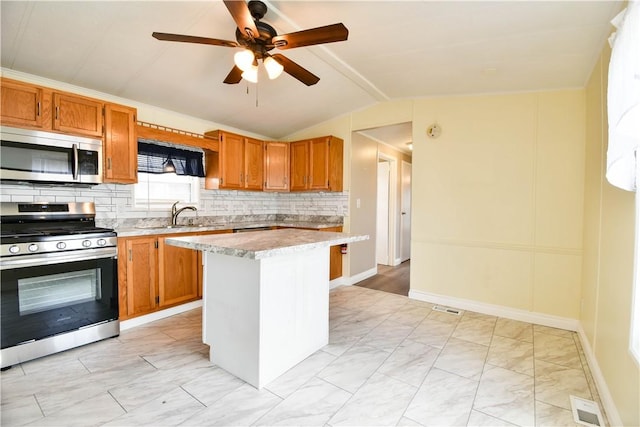 40 Lowell Ave, Pawtucket, RI 02861 - kitchen featuring appliances with stainless steel finishes, a sink, light marble finish floors, light countertops, and lofted ceiling