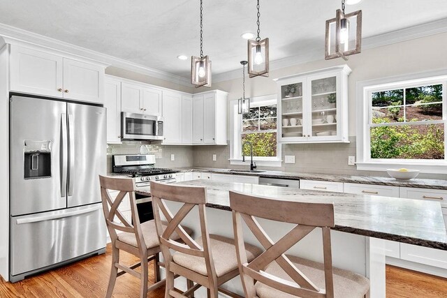 13 Vincent Way, Cumberland, RI 02864 - kitchen featuring stainless steel appliances, plenty of natural light, ornamental molding, a kitchen breakfast bar, and white cabinetry
