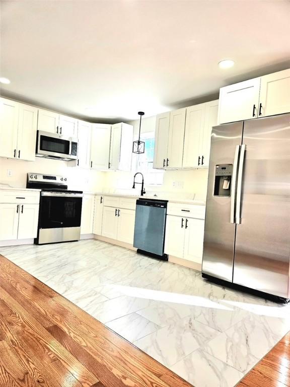90 Grove St, Providence, RI 02903 - kitchen featuring stainless steel appliances, light marble finish flooring, recessed lighting, light countertops, and hanging light fixtures