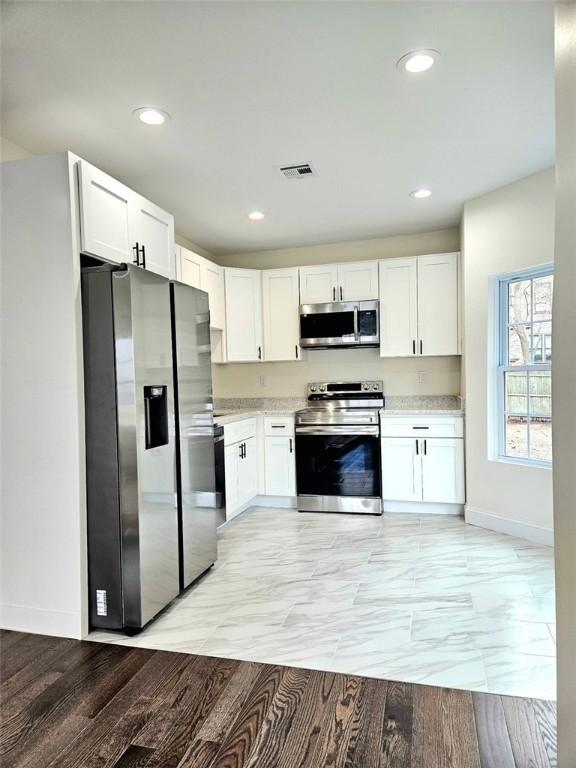 90 Grove St, Providence, RI 02903 - kitchen with appliances with stainless steel finishes, baseboards, white cabinetry, and recessed lighting