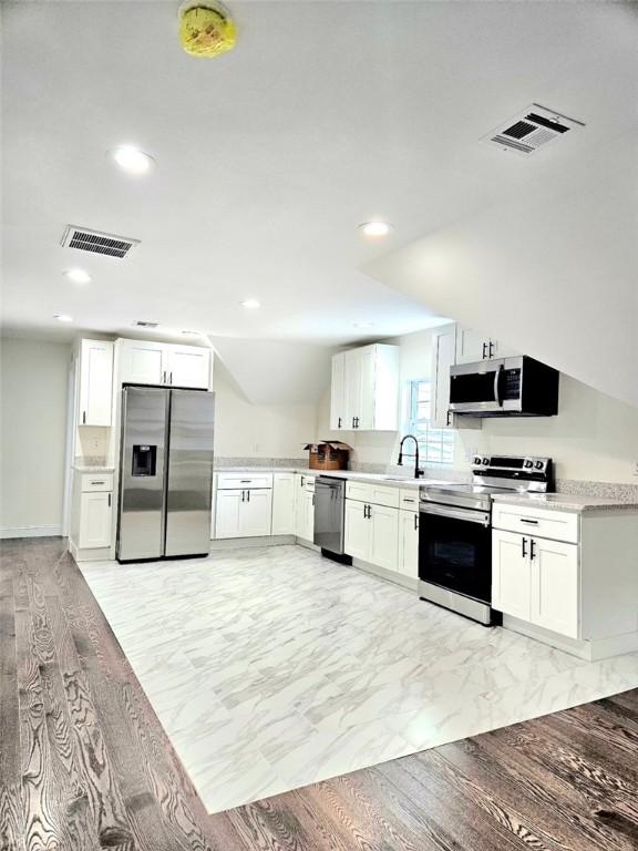 90 Grove St, Providence, RI 02903 - kitchen featuring appliances with stainless steel finishes, recessed lighting, white cabinets, light countertops, and a sink