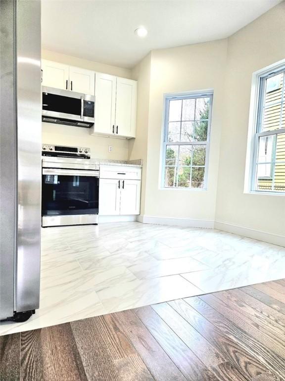 90 Grove St, Providence, RI 02903 - kitchen with stainless steel appliances, light marble finish flooring, white cabinetry, baseboards, and recessed lighting