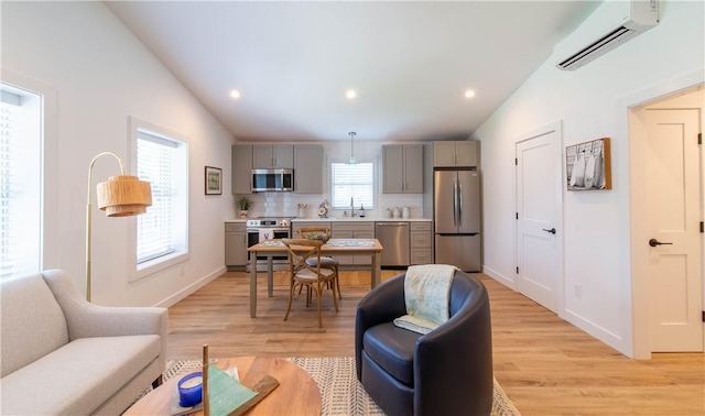 32 Exchange St Unit 104, East Greenwich, RI 02818 - living room with a wall mounted AC, light wood-type flooring, vaulted ceiling, baseboards, and recessed lighting