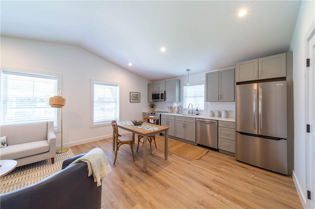 32 Exchange St Unit 104, East Greenwich, RI 02818 - kitchen featuring stainless steel appliances, gray cabinets, light wood finished floors, lofted ceiling, and light countertops