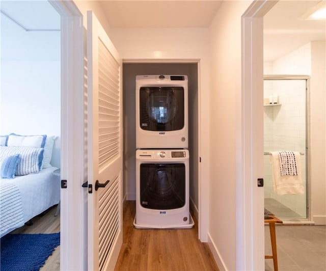 32 Exchange St Unit 104, East Greenwich, RI 02818 - washroom featuring stacked washing machine and dryer, wood finished floors, and baseboards