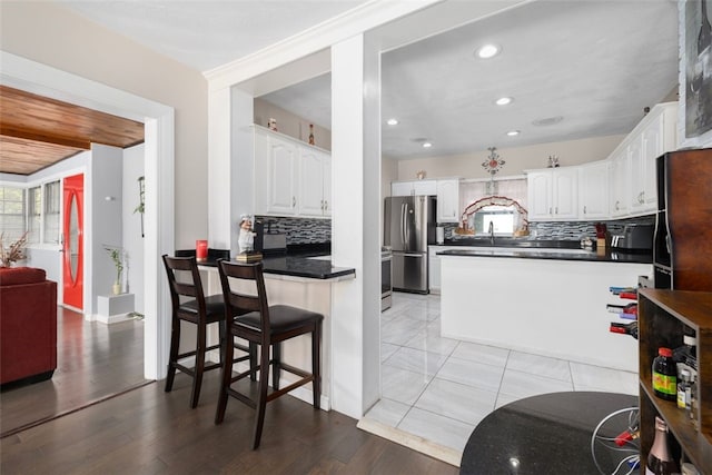 204 Reservoir Ave, Lincoln, RI 02865 - kitchen with freestanding refrigerator, a peninsula, decorative backsplash, white cabinetry, and recessed lighting
