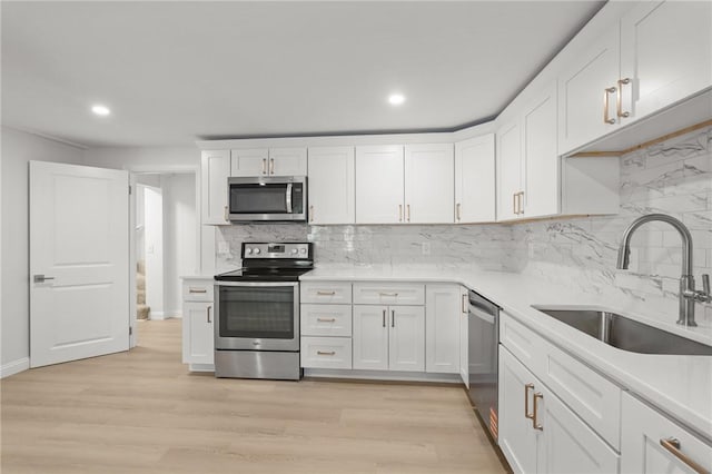 196 Stillwater Rd, Smithfield, RI 02917 - kitchen featuring appliances with stainless steel finishes, a sink, white cabinets, decorative backsplash, and light countertops