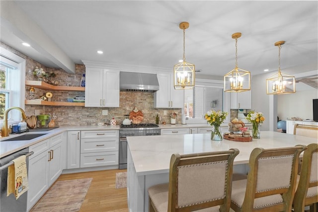 196 Stillwater Rd, Smithfield, RI 02917 - kitchen with wall chimney exhaust hood, a sink, stainless steel appliances, a chandelier, and decorative backsplash