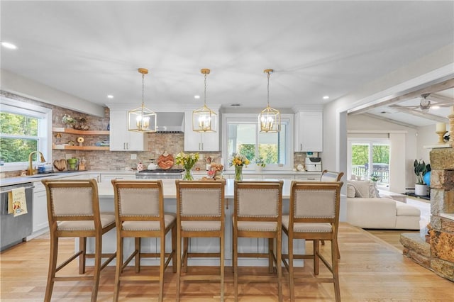 196 Stillwater Rd, Smithfield, RI 02917 - kitchen with stainless steel dishwasher, white cabinetry, decorative backsplash, lofted ceiling, and light countertops