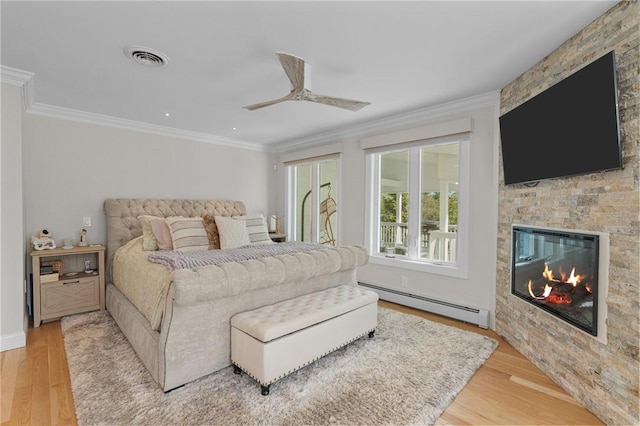 196 Stillwater Rd, Smithfield, RI 02917 - bedroom featuring baseboard heating, light wood finished floors, crown molding, a large fireplace, and ceiling fan
