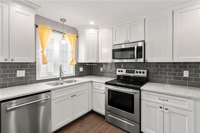 228 Morse Ave, Woonsocket, RI 02895 - kitchen with appliances with stainless steel finishes, a sink, white cabinets, decorative light fixtures, and decorative backsplash