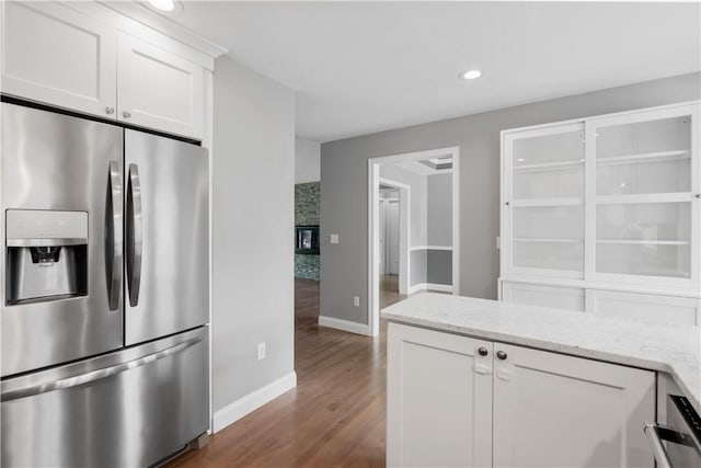 228 Morse Ave, Woonsocket, RI 02895 - kitchen featuring stainless steel fridge, dark wood-style flooring, baseboards, white cabinets, and light stone counters