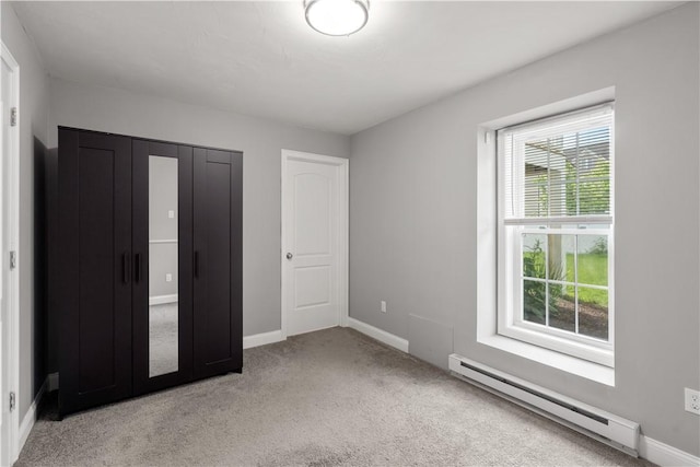 228 Morse Ave, Woonsocket, RI 02895 - unfurnished bedroom featuring baseboard heating, light colored carpet, baseboards, and a closet