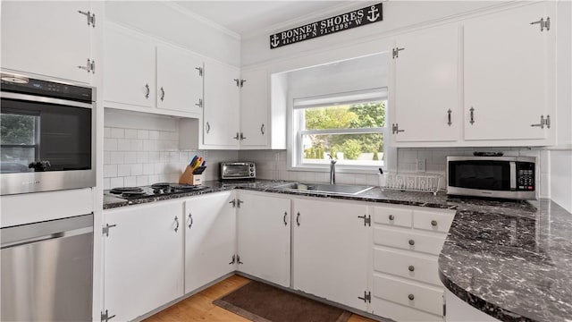 21 Meadowrue Trl, Narragansett, RI 02874 - kitchen featuring appliances with stainless steel finishes, a sink, white cabinetry, tasteful backsplash, and crown molding