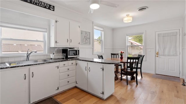 21 Meadowrue Trl, Narragansett, RI 02874 - kitchen featuring a sink, light wood-style flooring, white cabinets, a peninsula, and stainless steel microwave