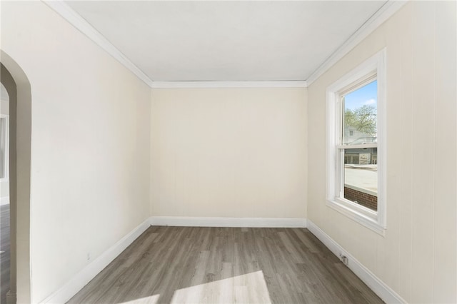 1875 Smith St, North Providence, RI 02911 - empty room featuring crown molding, wood finished floors, arched walkways, and baseboards
