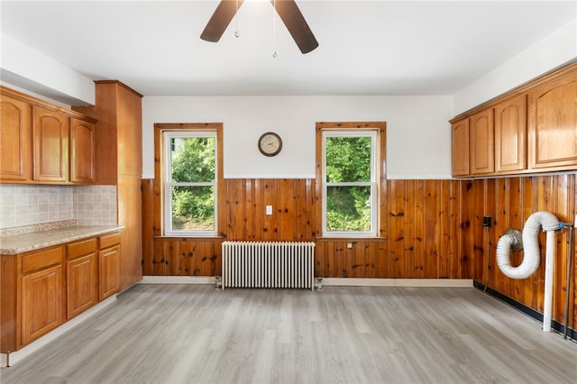 1875 Smith St, North Providence, RI 02911 - kitchen with radiator heating unit, a wainscoted wall, light wood-style flooring, a ceiling fan, and brown cabinetry