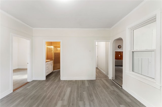 1875 Smith St, North Providence, RI 02911 - unfurnished bedroom with arched walkways, light wood finished floors, crown molding, and baseboards