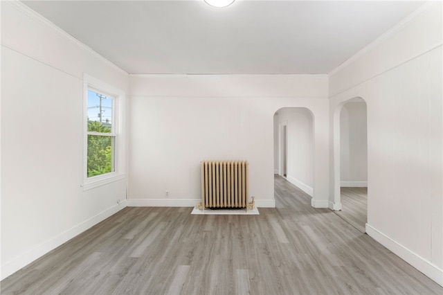 1875 Smith St, North Providence, RI 02911 - unfurnished room with radiator heating unit, ornamental molding, light wood-style flooring, arched walkways, and baseboards