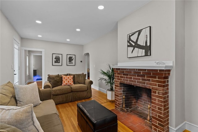 36 Ruth Ave, East Providence, RI 02916 - living room featuring arched walkways, wood finished floors, recessed lighting, a brick fireplace, and baseboards