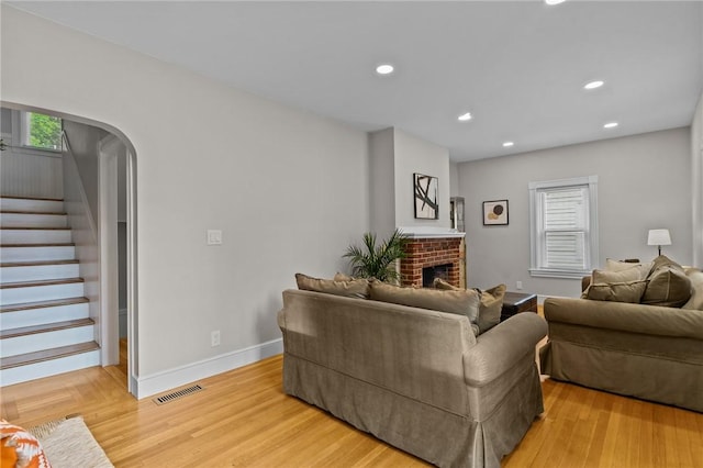 36 Ruth Ave, East Providence, RI 02916 - living area with stairway, a brick fireplace, recessed lighting, light wood-type flooring, and arched walkways
