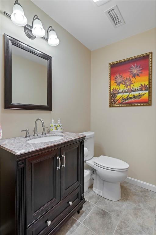 101 Huckleberry Rd, North Kingstown, RI 02852 - half bath featuring toilet, vanity, baseboards, and tile patterned flooring