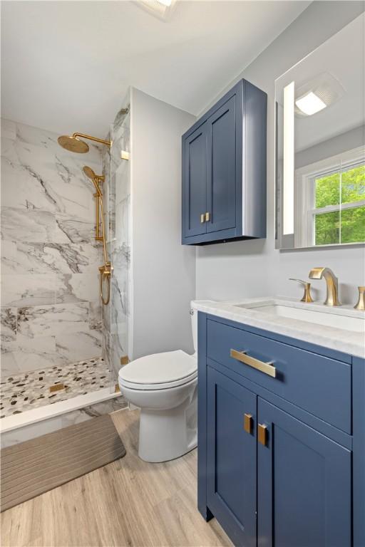 101 Huckleberry Rd, North Kingstown, RI 02852 - full bathroom featuring vanity, toilet, a marble finish shower, and wood finished floors