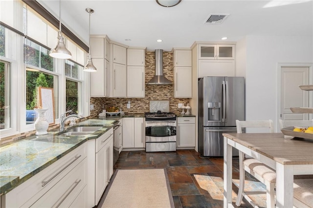 85 Frigate St, Jamestown, RI 02832 - kitchen featuring stainless steel appliances, wall chimney range hood, a sink, backsplash, and dark stone finish floors