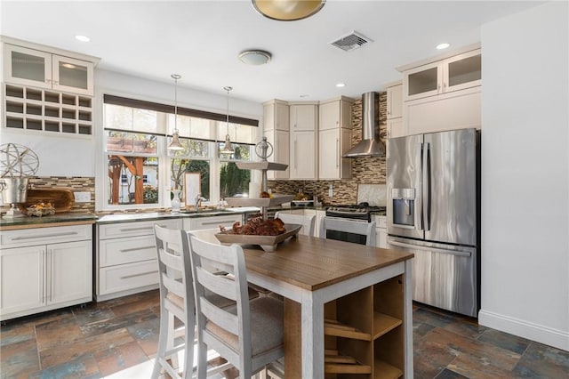 85 Frigate St, Jamestown, RI 02832 - kitchen featuring appliances with stainless steel finishes, wall chimney exhaust hood, stone tile floors, tasteful backsplash, and a sink