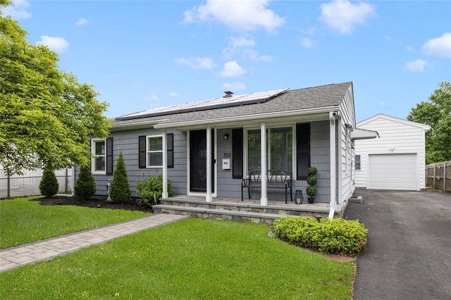 150 Memorial Dr, Pawtucket, RI 02860 - view of front of home featuring a porch, roof mounted solar panels, a garage, asphalt driveway, and an outbuilding