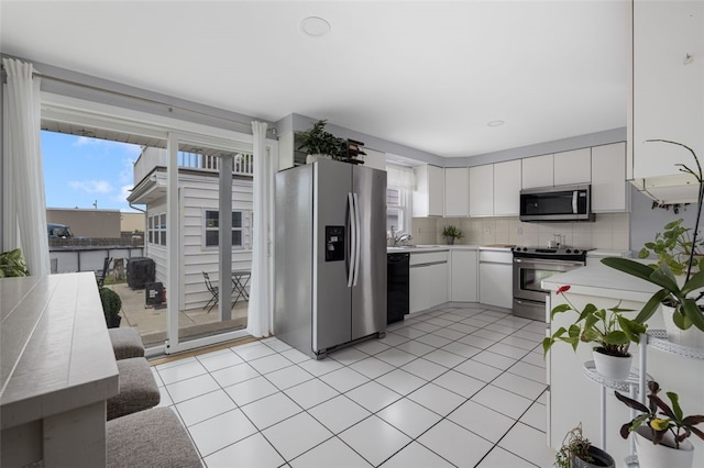 150 Memorial Dr, Pawtucket, RI 02860 - kitchen featuring appliances with stainless steel finishes, light countertops, tasteful backsplash, light tile patterned flooring, and plenty of natural light