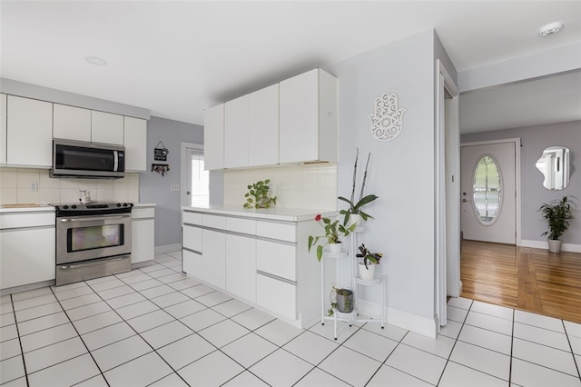 150 Memorial Dr, Pawtucket, RI 02860 - kitchen featuring appliances with stainless steel finishes, light countertops, decorative backsplash, and light tile patterned floors