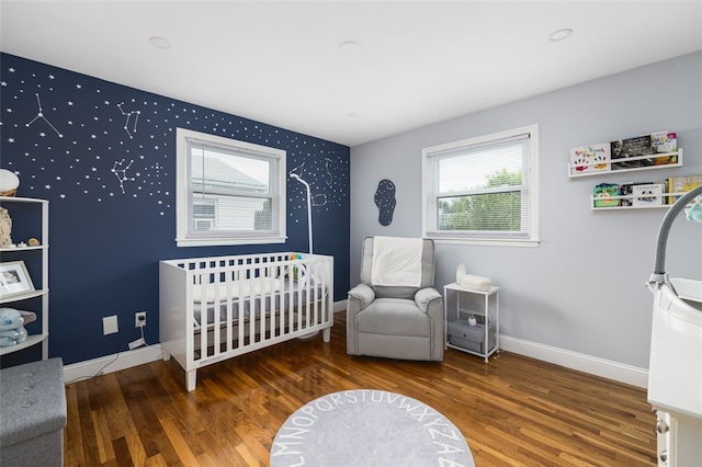 150 Memorial Dr, Pawtucket, RI 02860 - bedroom with wood finished floors, a nursery area, and an accent wall