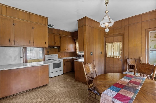 8 Tampa St, West Warwick, RI 02893 - kitchen with white electric stove, brown cabinetry, light countertops, wooden walls, and a sink