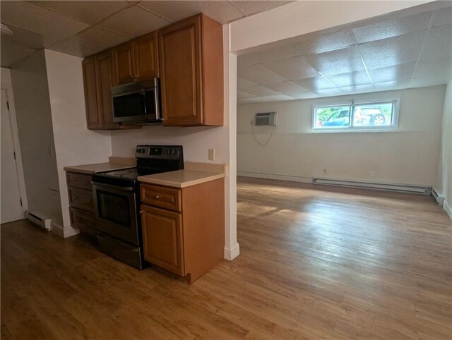300 Smithfield Rd Unit P2-2, North Providence, RI 02904 - kitchen with appliances with stainless steel finishes, a paneled ceiling, baseboard heating, a baseboard radiator, and brown cabinets