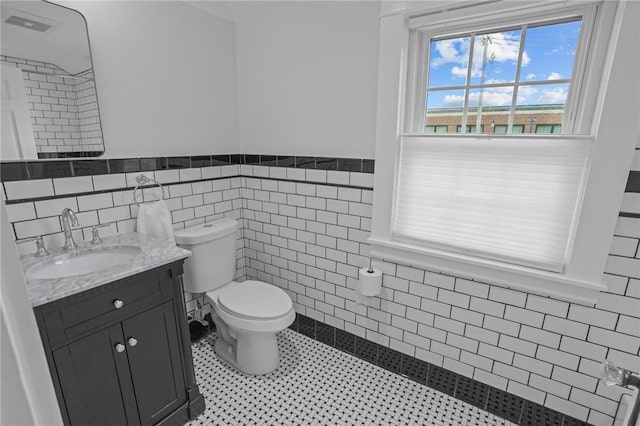 11 Elmcroft Ave, Providence, RI 02909 - bathroom featuring tile walls, vanity, toilet, and a wainscoted wall