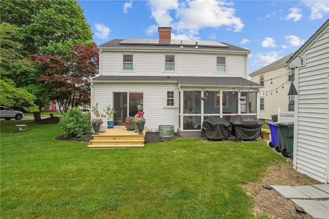 11 Elmcroft Ave, Providence, RI 02909 - back of house with a sunroom, roof mounted solar panels, a chimney, a yard, and roof with shingles