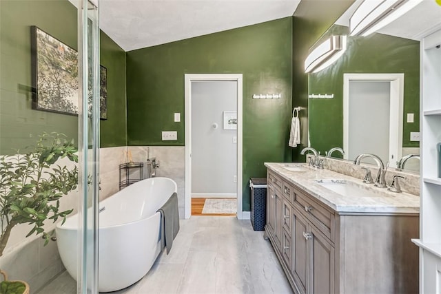 11 Noto Dr, North Providence, RI 02904 - bathroom featuring double vanity, a soaking tub, vaulted ceiling, and tile walls