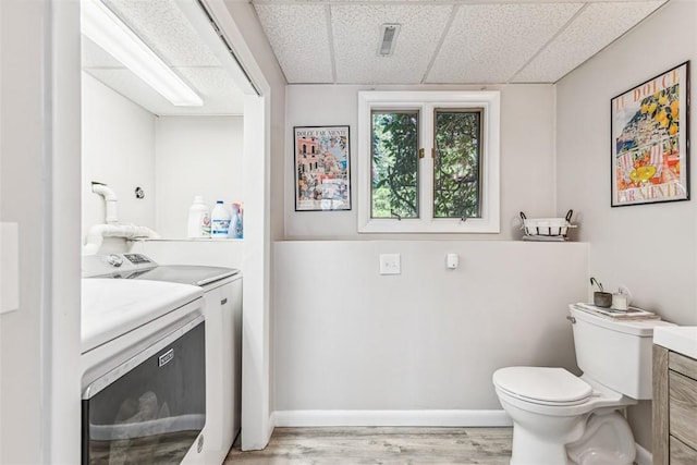 11 Noto Dr, North Providence, RI 02904 - bathroom featuring separate washer and dryer, vanity, toilet, wood finished floors, and a paneled ceiling