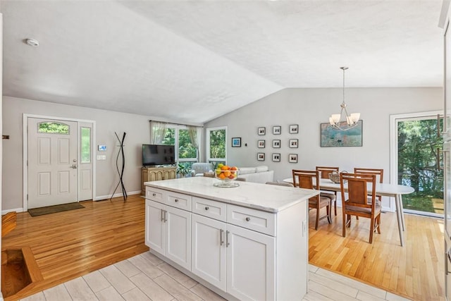 11 Noto Dr, North Providence, RI 02904 - kitchen featuring light wood-style floors, white cabinets, light stone counters, a chandelier, and vaulted ceiling
