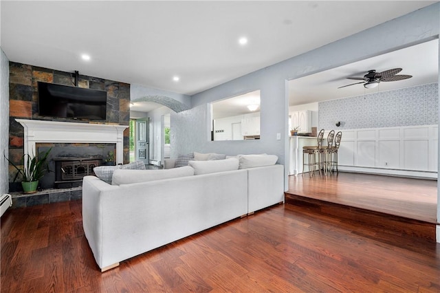 8 Westgate Rd, Cumberland, RI 02864 - living area featuring a baseboard radiator, wood finished floors, wallpapered walls, a ceiling fan, and a tiled fireplace