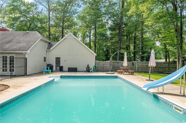 8 Westgate Rd, Cumberland, RI 02864 - view of swimming pool featuring a water slide, a patio area, a fenced backyard, french doors, and view of scattered trees