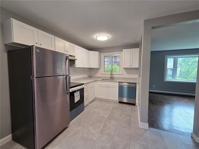 119 Evergreen Ave, Tiverton, RI 02878 - kitchen featuring stainless steel appliances, a baseboard heating unit, a sink, light countertops, and white cabinets