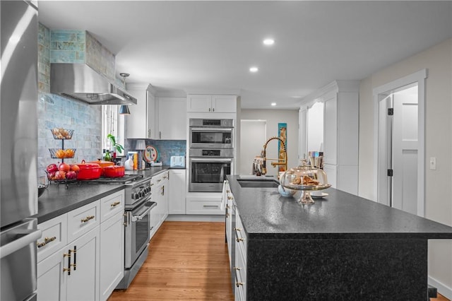 25 King Philip Rd, Pawtucket, RI 02861 - kitchen with dark countertops, stainless steel appliances, an island with sink, backsplash, and a sink