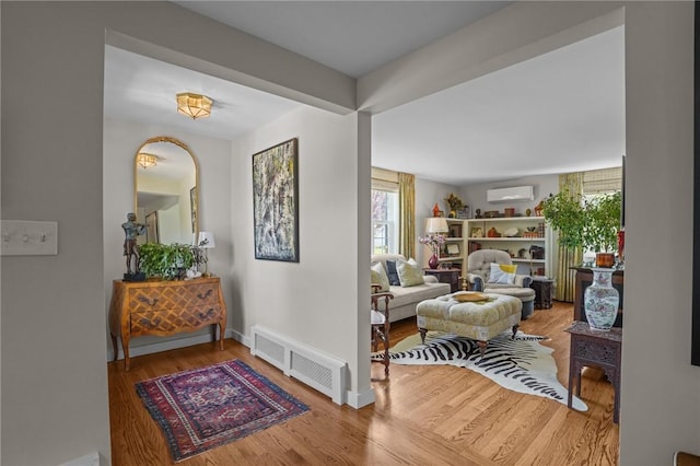 25 King Philip Rd, Pawtucket, RI 02861 - living area featuring a wall unit AC, wood finished floors, and baseboards