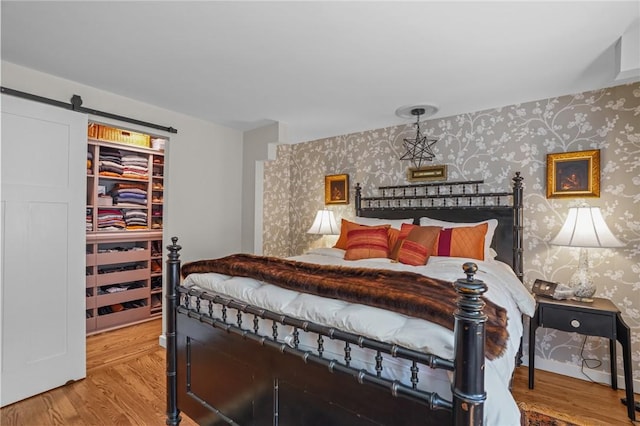 25 King Philip Rd, Pawtucket, RI 02861 - bedroom featuring wallpapered walls, wood finished floors, and a barn door