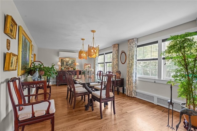 25 King Philip Rd, Pawtucket, RI 02861 - dining space featuring a chandelier, an AC wall unit, light wood finished floors, and radiator heating unit