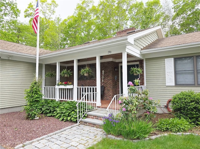 190 Broad Rock Rd, South Kingstown, RI 02879 - view of exterior entry with a porch, a chimney, brick siding, and a shingled roof